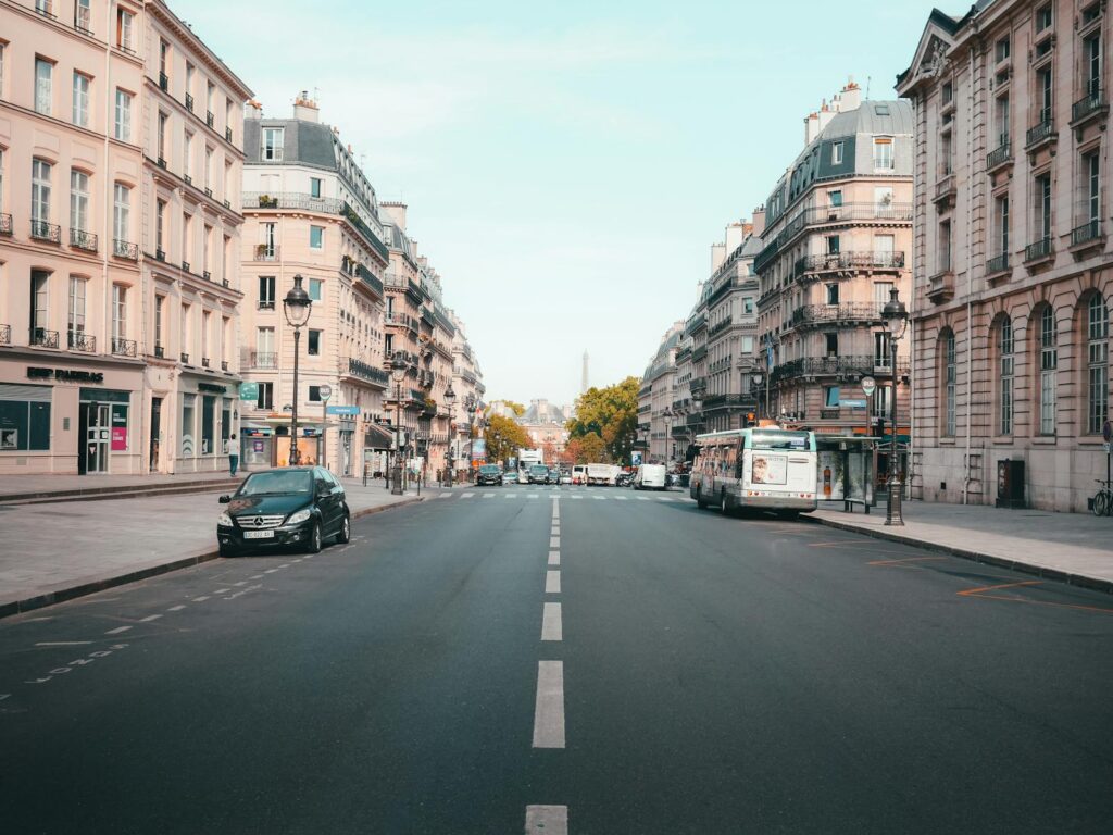 Explore a typical Parisian street lined with classic architecture and bustling urban activity.