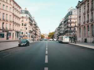Explore a typical Parisian street lined with classic architecture and bustling urban activity.